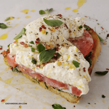 close up of half burrata toast drizzled with EVOO.