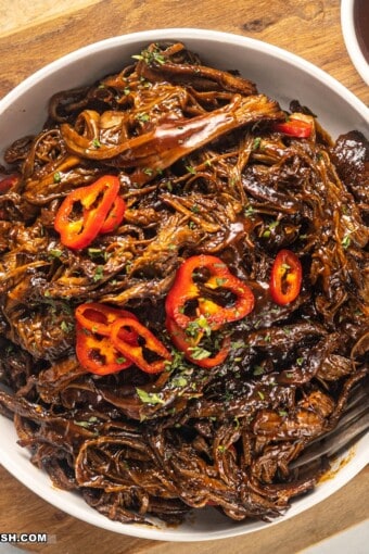 close up image of slow-cooked pulled brisket in a bowl.