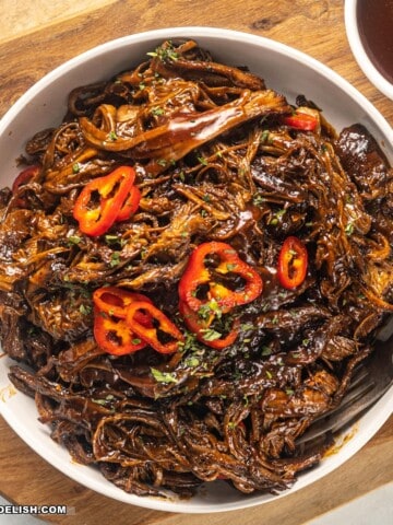 close up image of slow-cooked pulled brisket in a bowl.