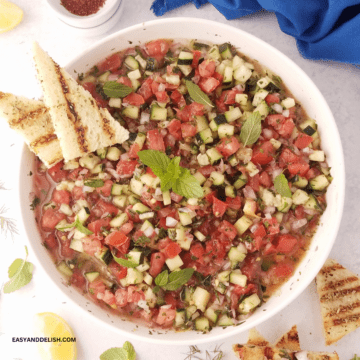 A bowl of shirazi salad with a mini toast on the side.