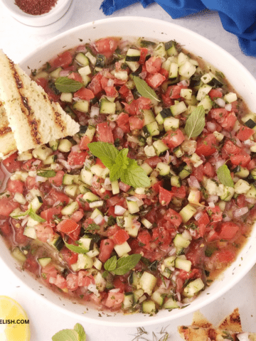 A bowl of shirazi salad with a mini toast on the side.