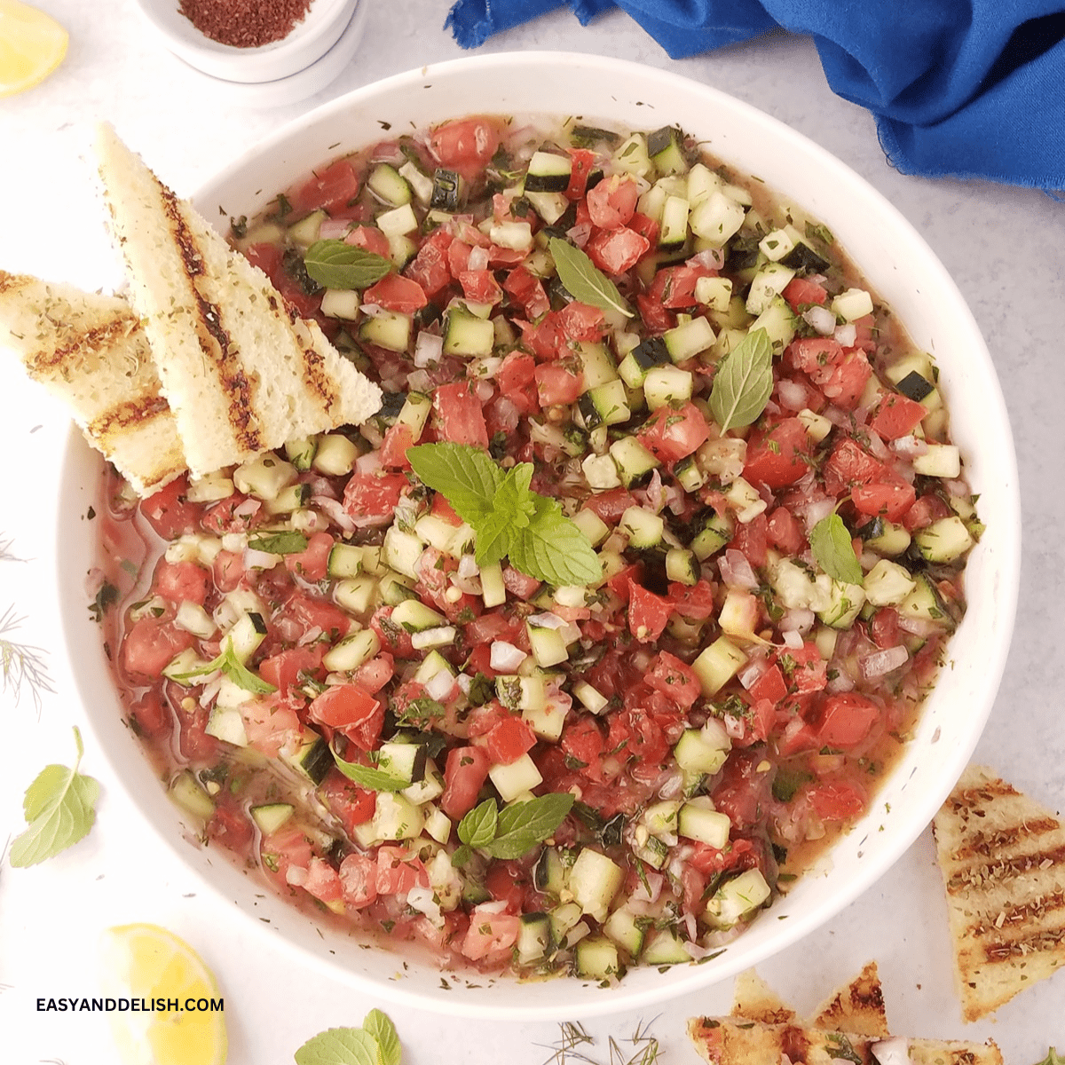 A bowl of shirazi salad with a mini toast on the side.
