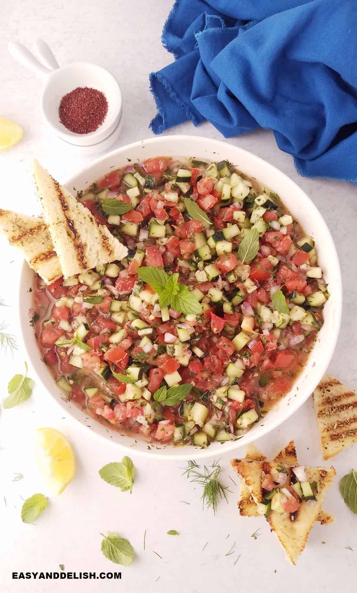 Iranian chopped salad with mini toasts plus lemon wedges and sumac on the side.