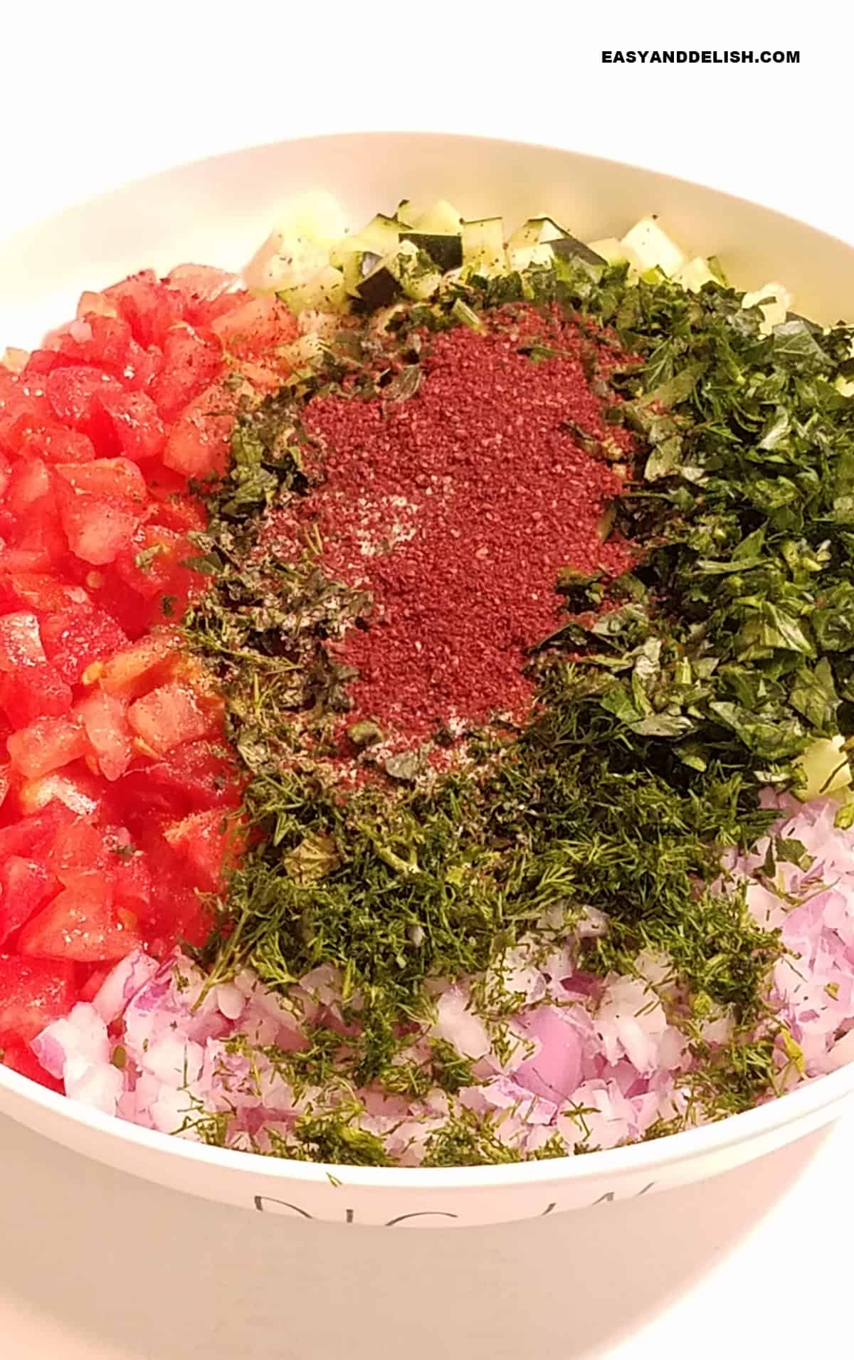 fresh herbs and seasonings plus sumac in a bowl.