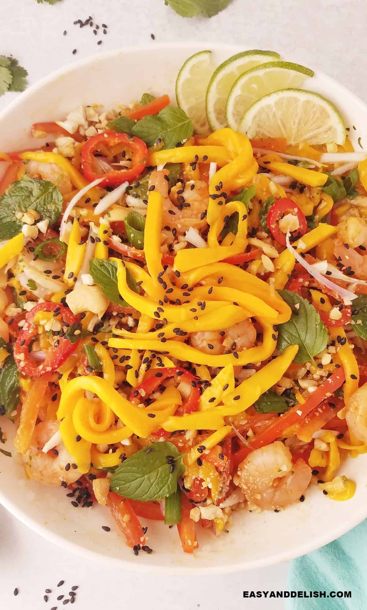 a large bowl of spicy thai mango salad with shrimp.