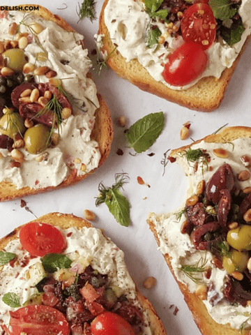 close up of several ricotta toasts with two different savory toppings.