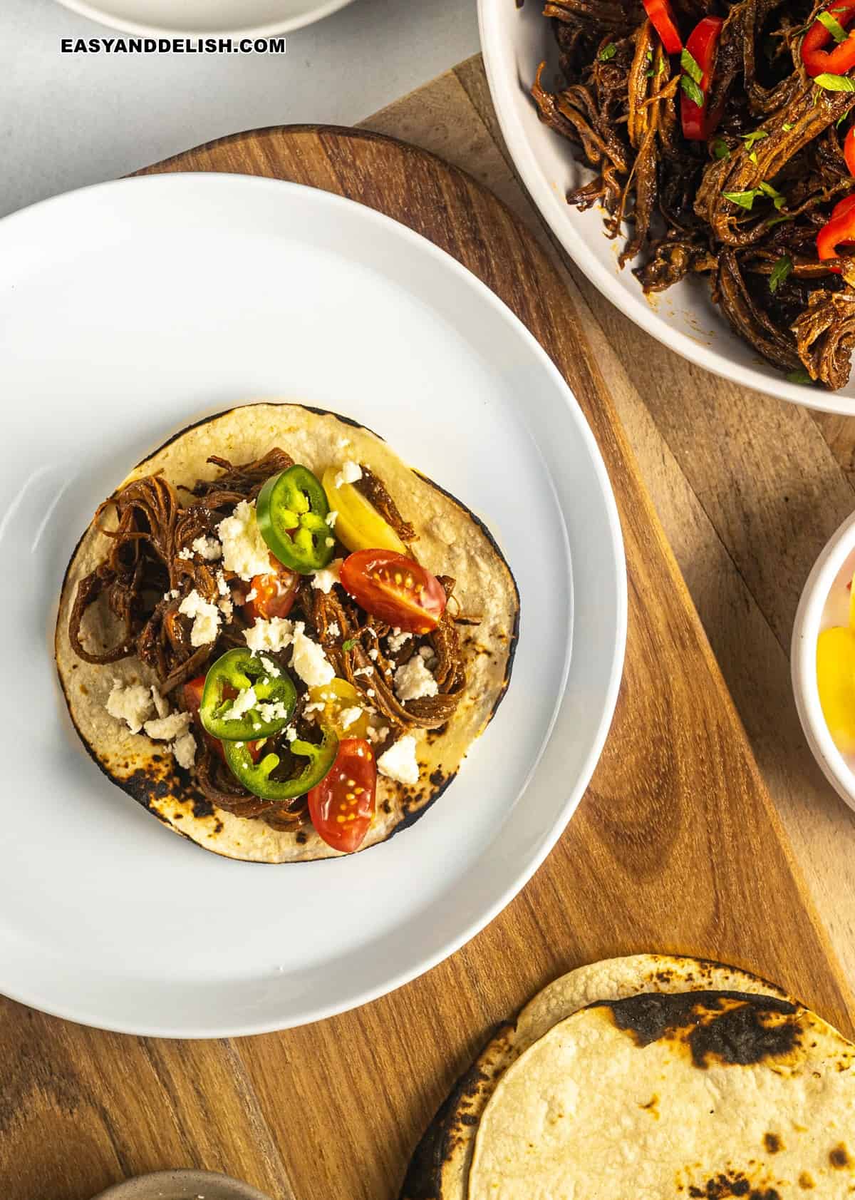 pulled brisket on corn tortillas garnished with jalapeno, tomatoes, and queso cotija. 