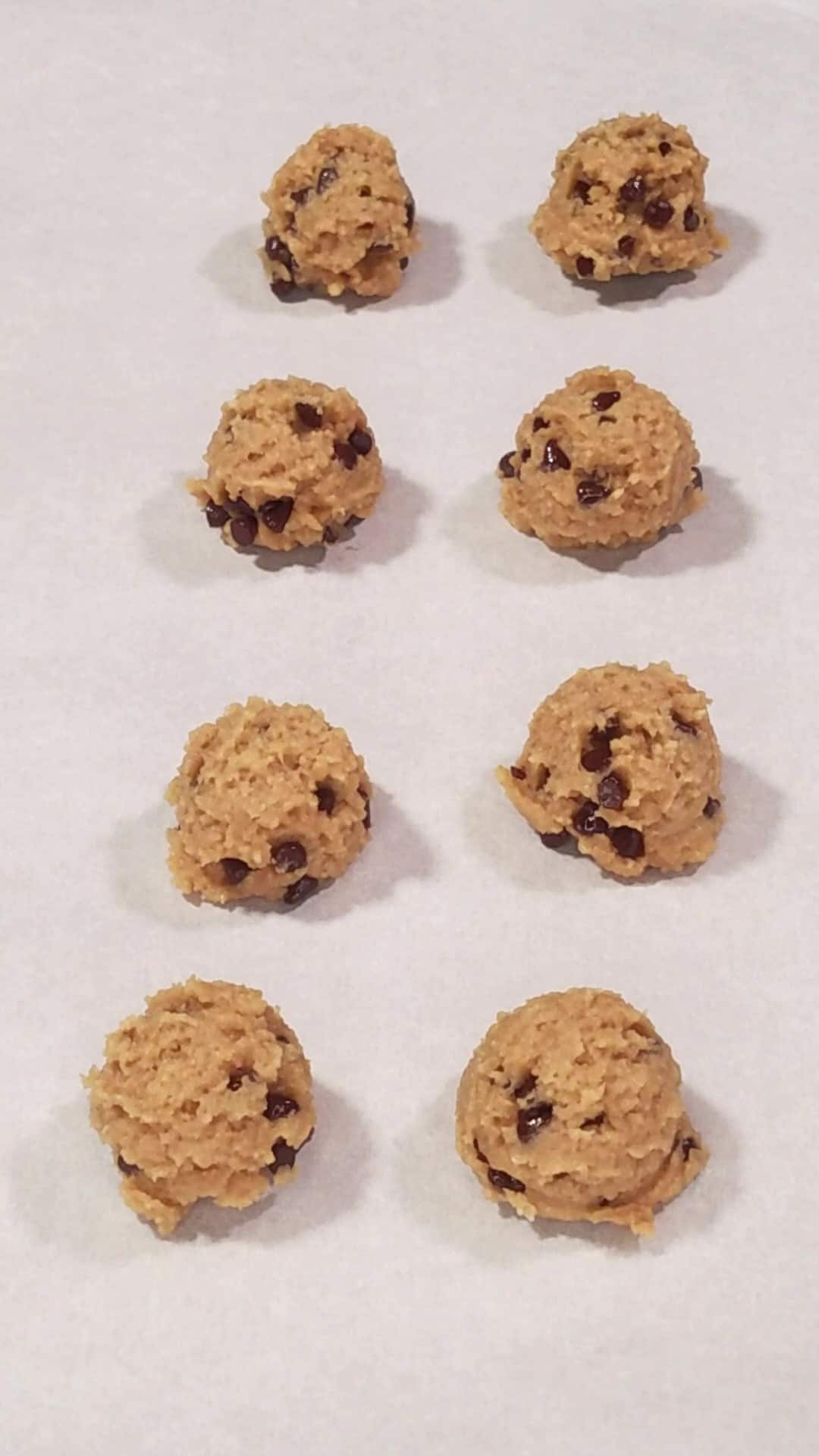 Placing protein balls onto a cookie sheet to freeze. 