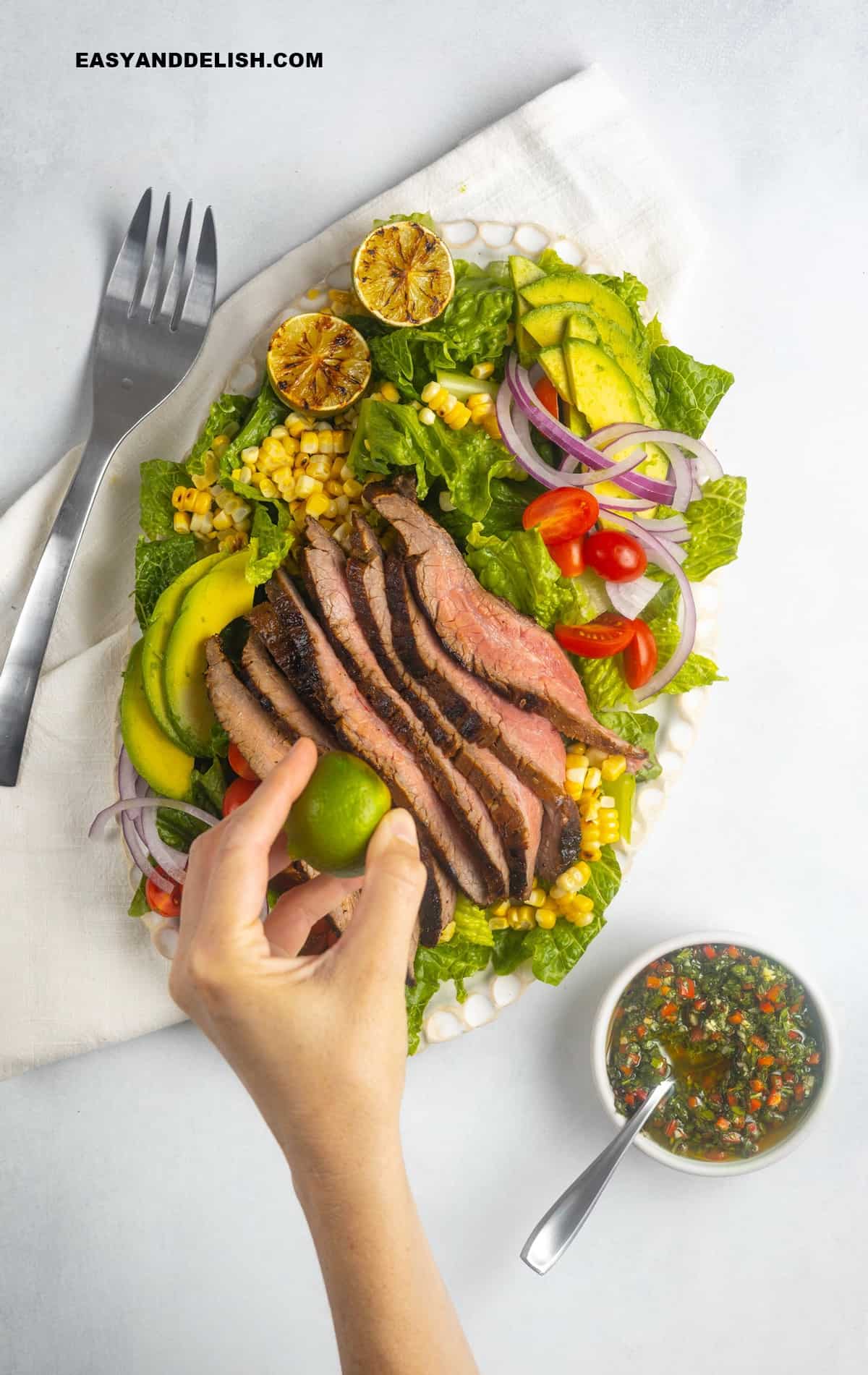 Lime squeezed over grilled flank steak salad.