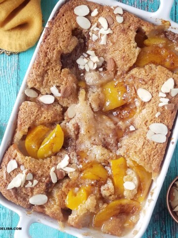 close up of easy lazy man's peach cobbler with canned peaches and toasted almonds on top.