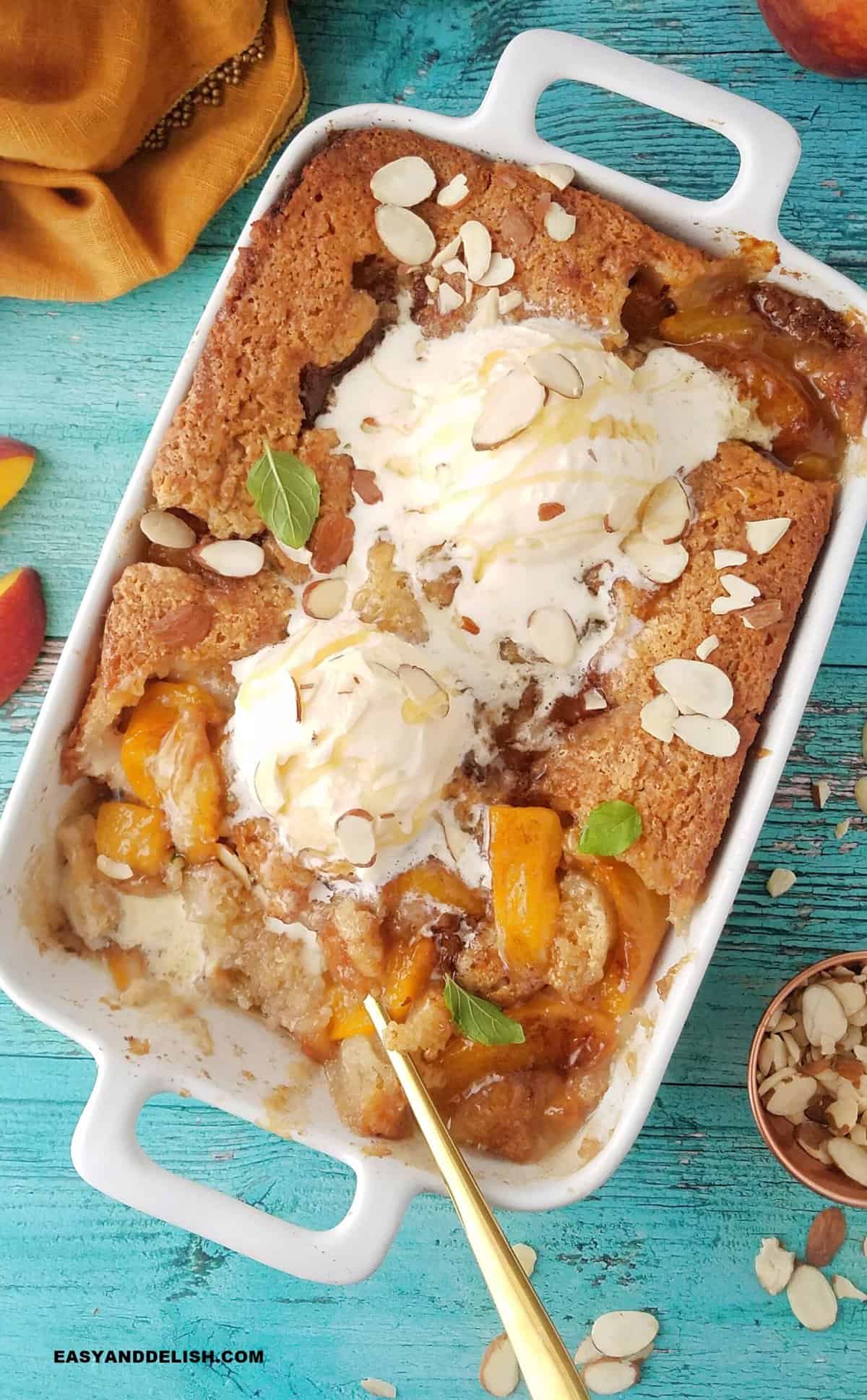 peach cobbler with canned peached topped with scoops of vanulla ice cream.