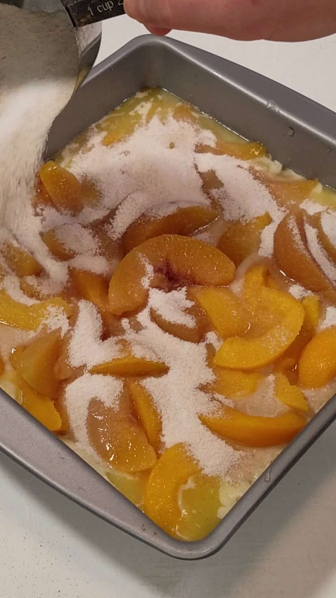 sugar-cinnamon mixture sprinkled on top of the layers of peach cobbler.