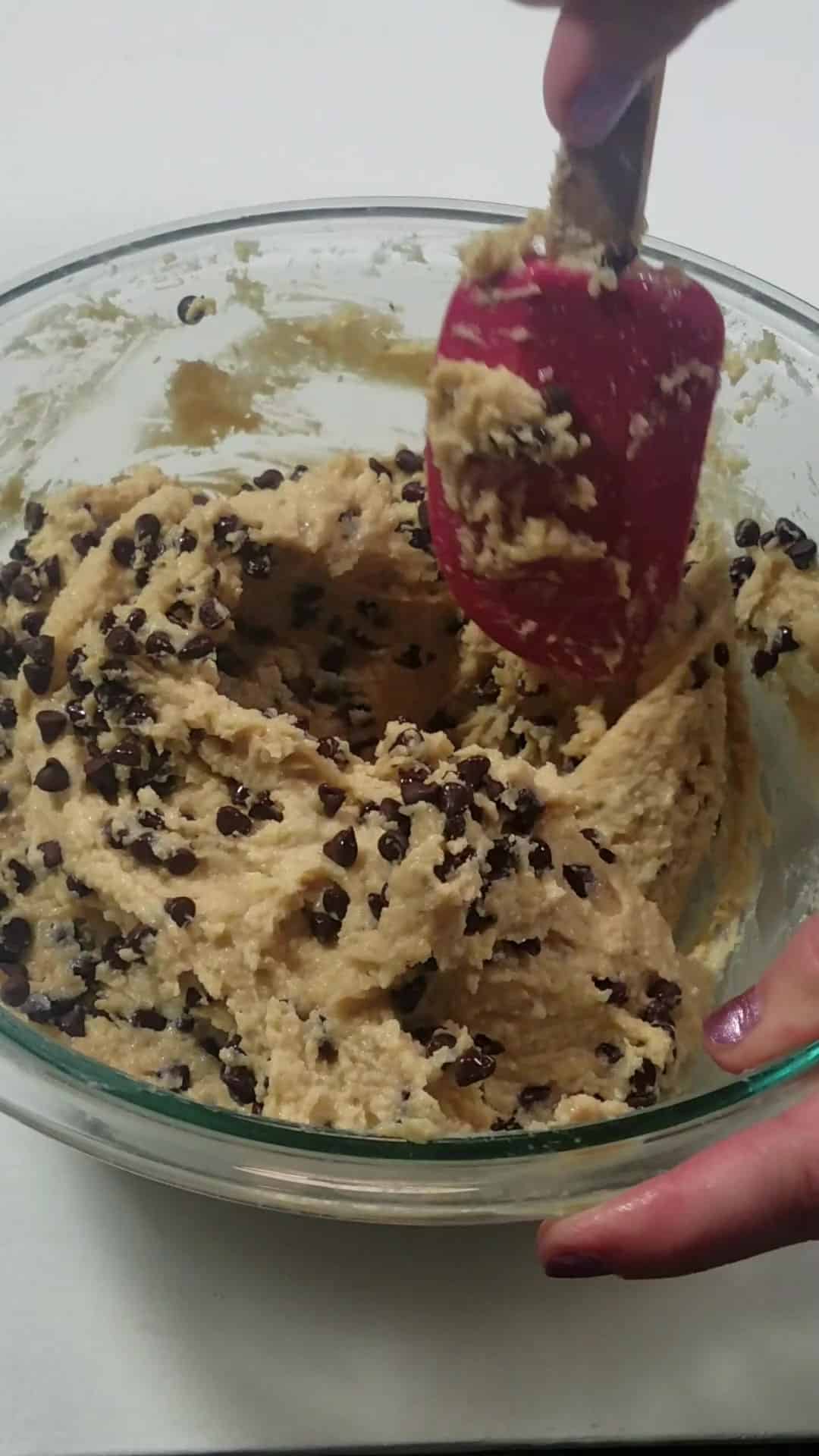 folding in chocolate chips in a bowl.