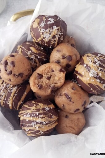 several cookie dough protein balls piled up in a basket.