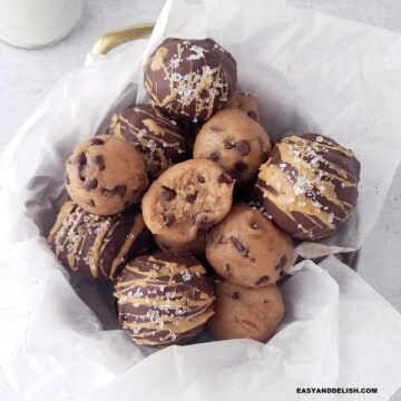 several cookie dough protein balls piled up in a basket.