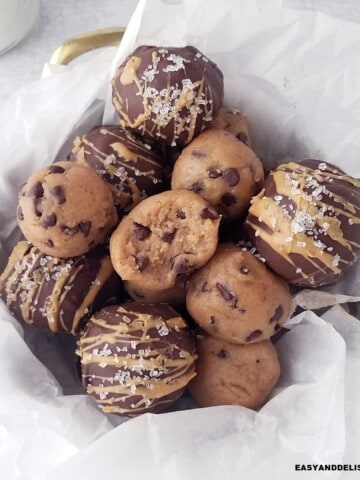 several cookie dough protein balls piled up in a basket.