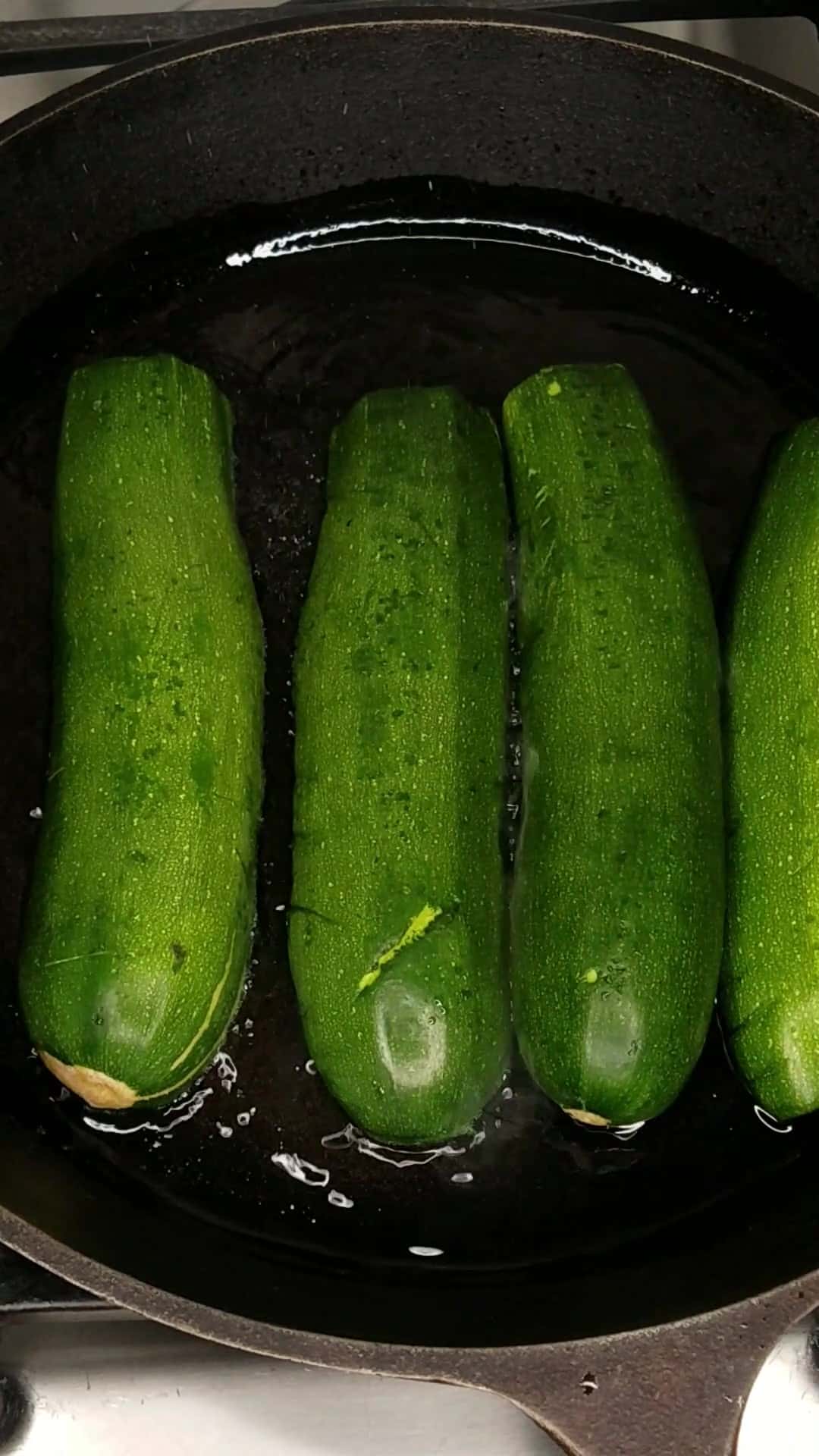 Browning zucchini face down on the stovetop.