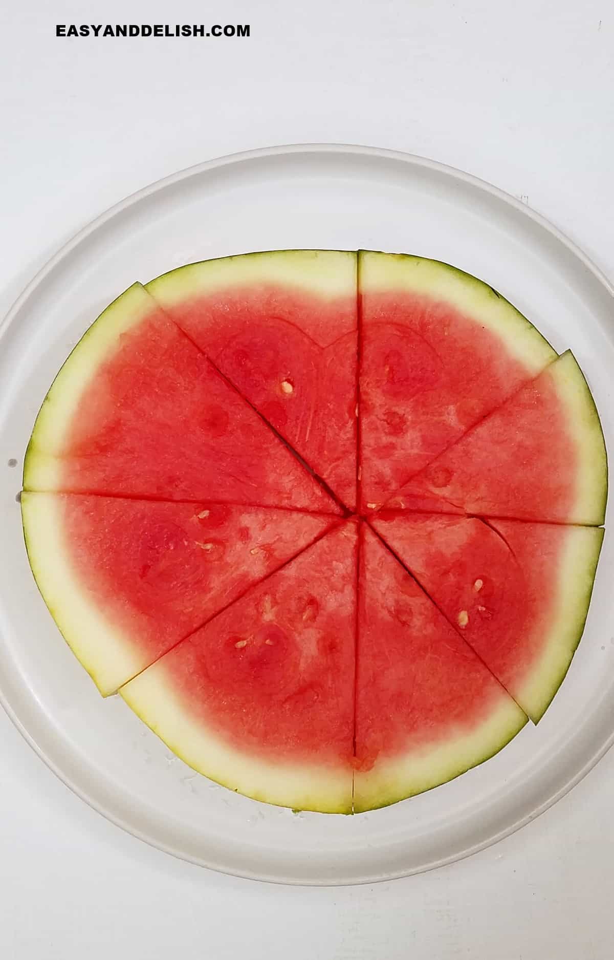 a slice of the summer fruit in a plate cut into wedges.