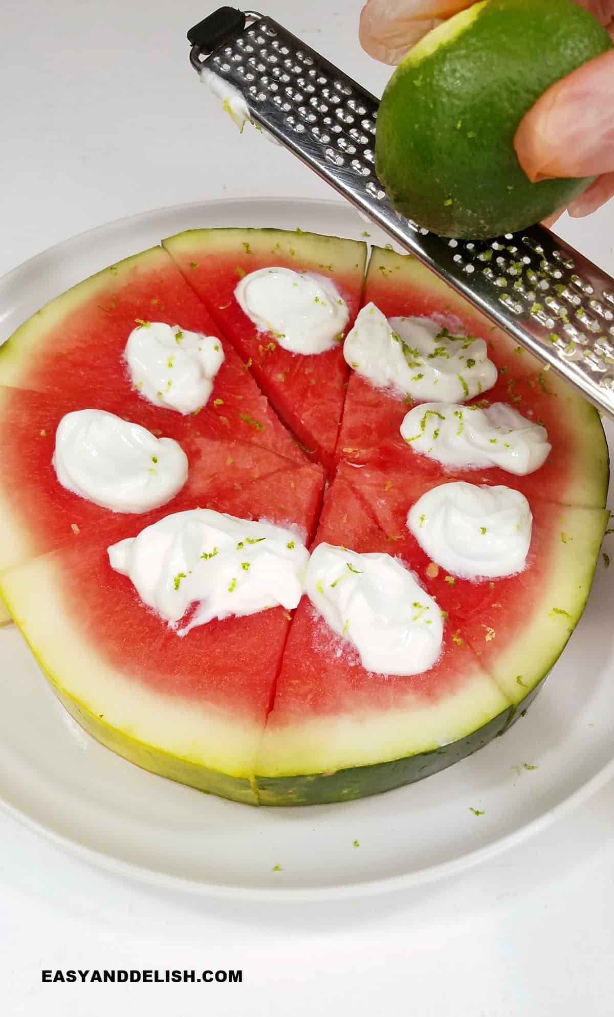 lime zested over a a slice of the fruit topped with yogurt.