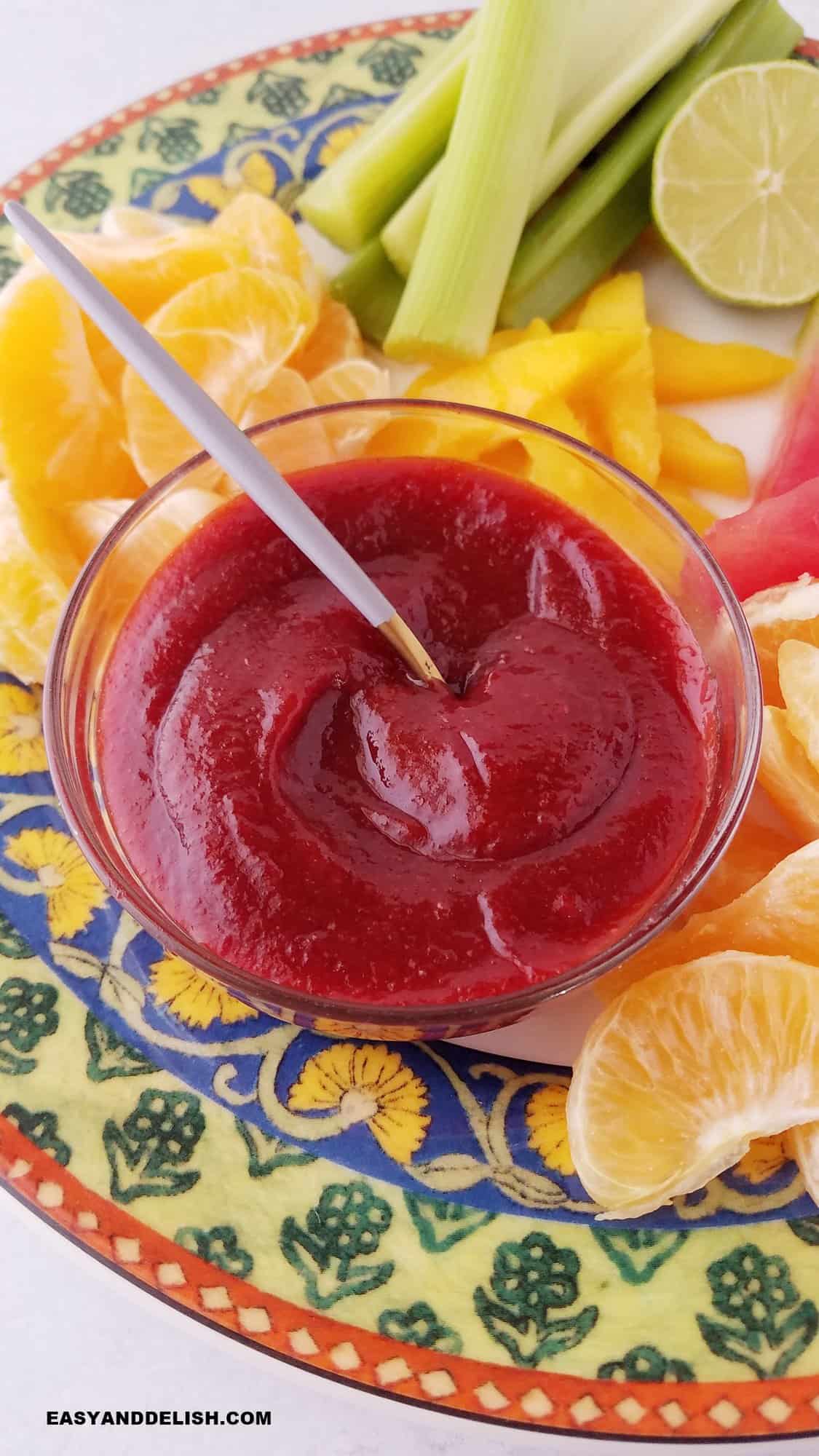 a platter with fresh fruits and chamoy sauce. 