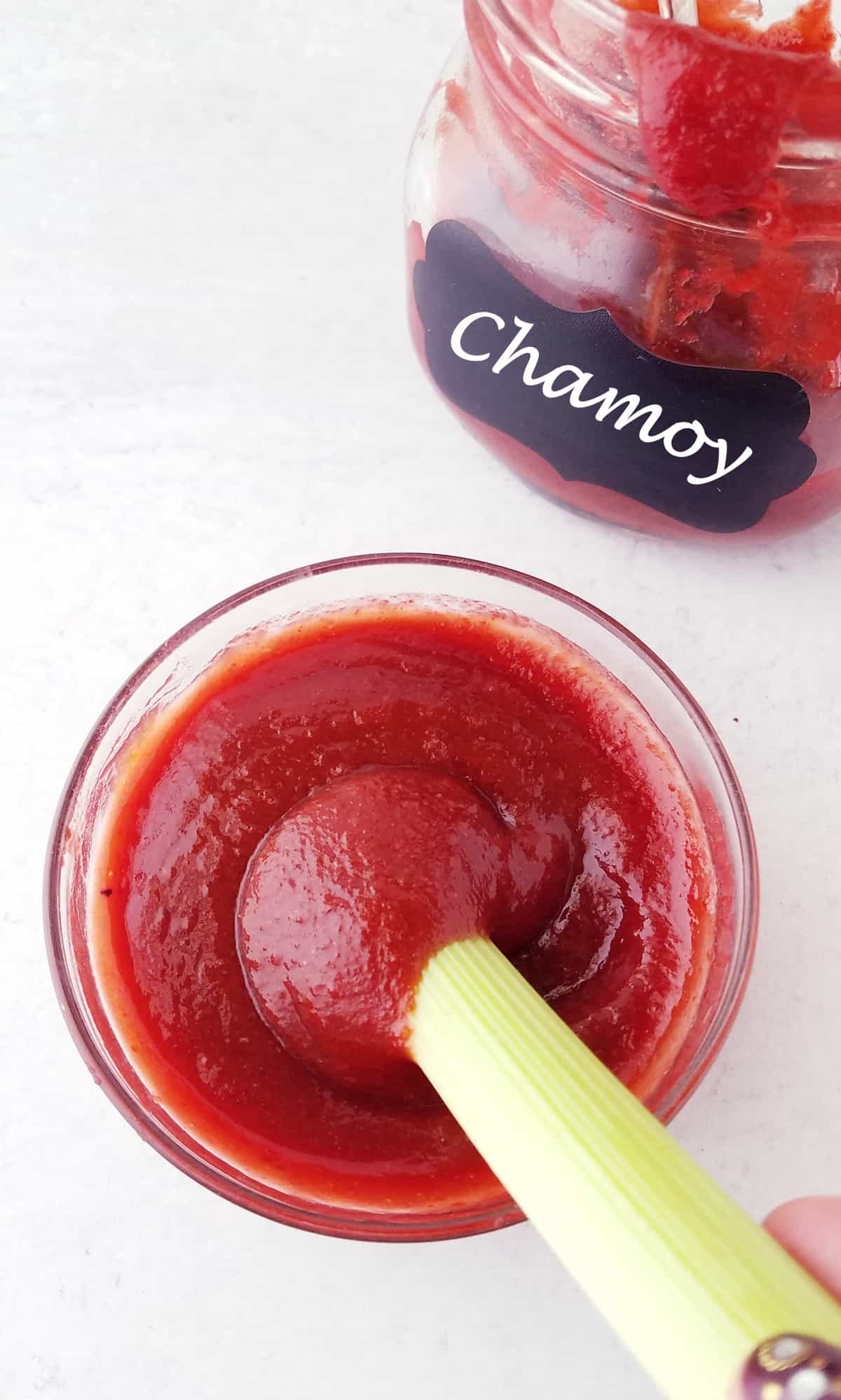 celery stalk dipped into a bowl of Mexican chamoy sauce.