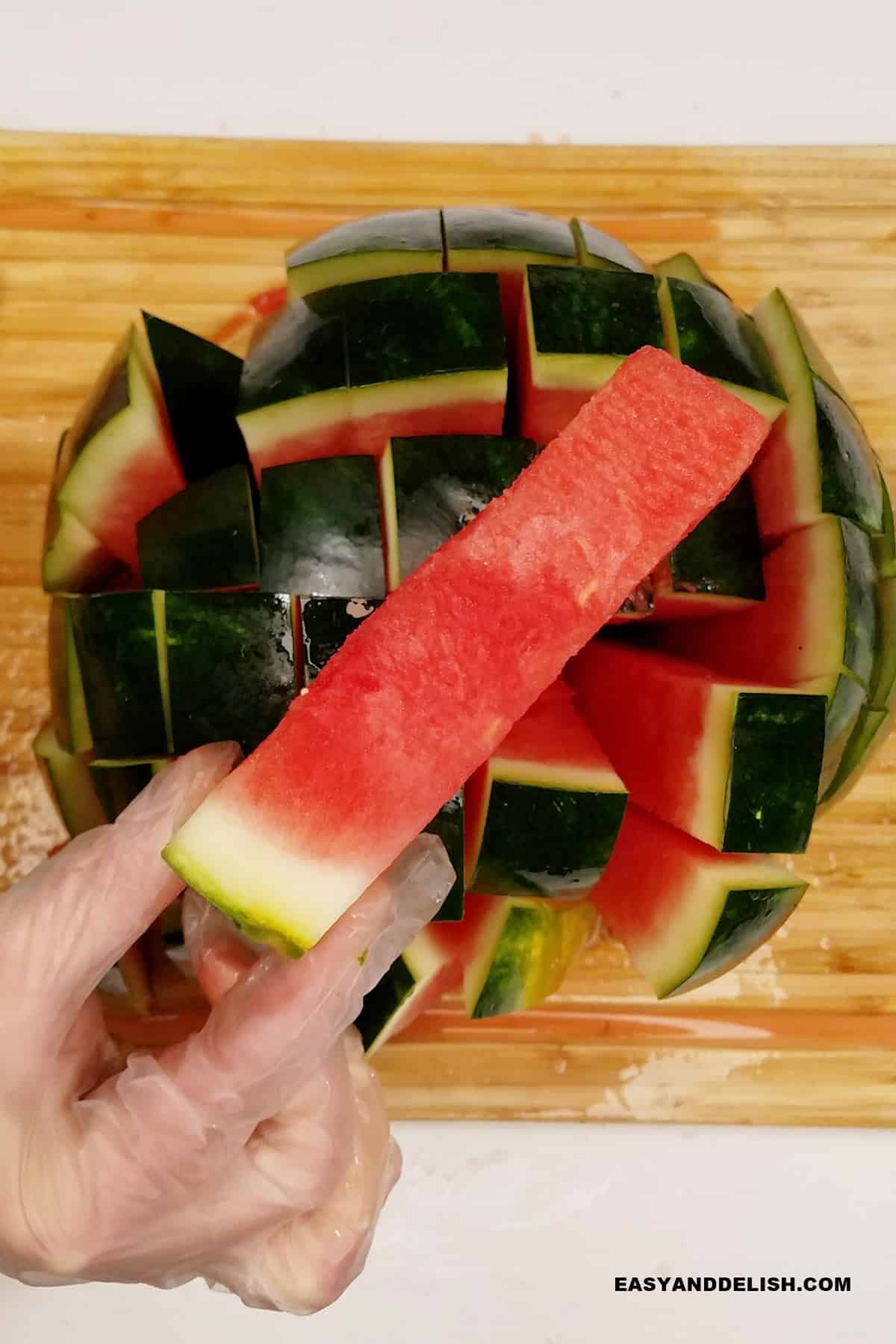 a hand holdinga  melon stick.