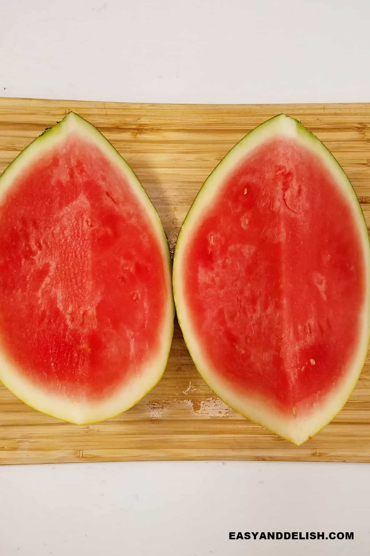 melon cut into quarters on a cutting board. 