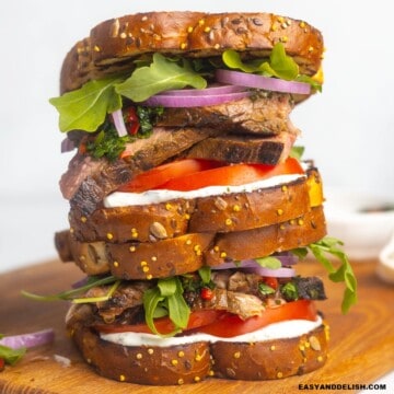 A pile of steak sandwich on a cutting board.
