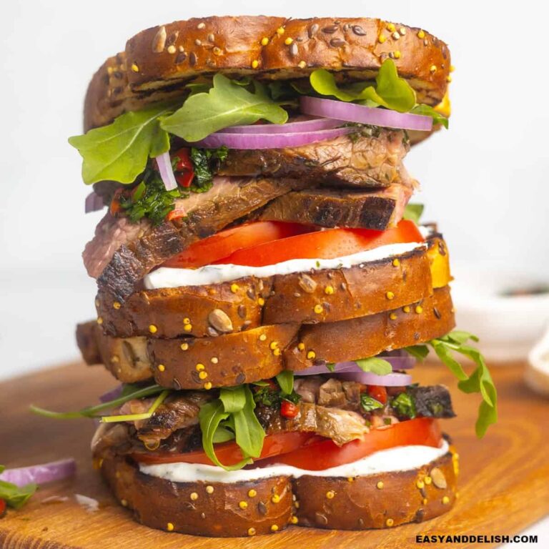 A pile of steak sandwich on a cutting board.