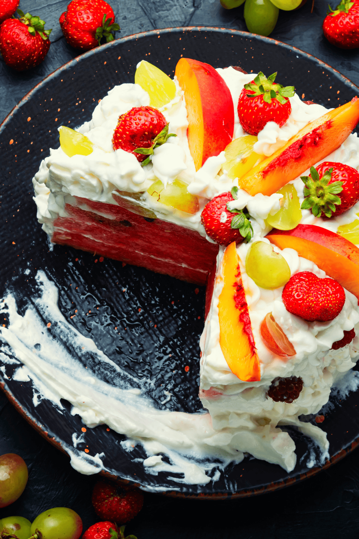 layered melon cake with frosting and fruits on top.
