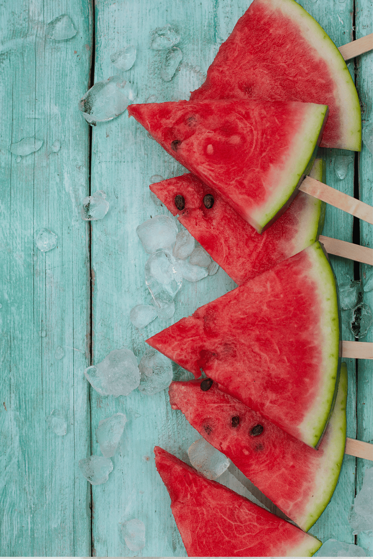 melon pops with ice cubes on a table.