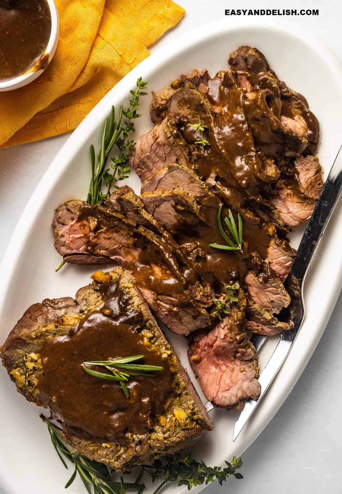 slow-roasted roast beef, partially sliced, and then topped with gravy and herbs.