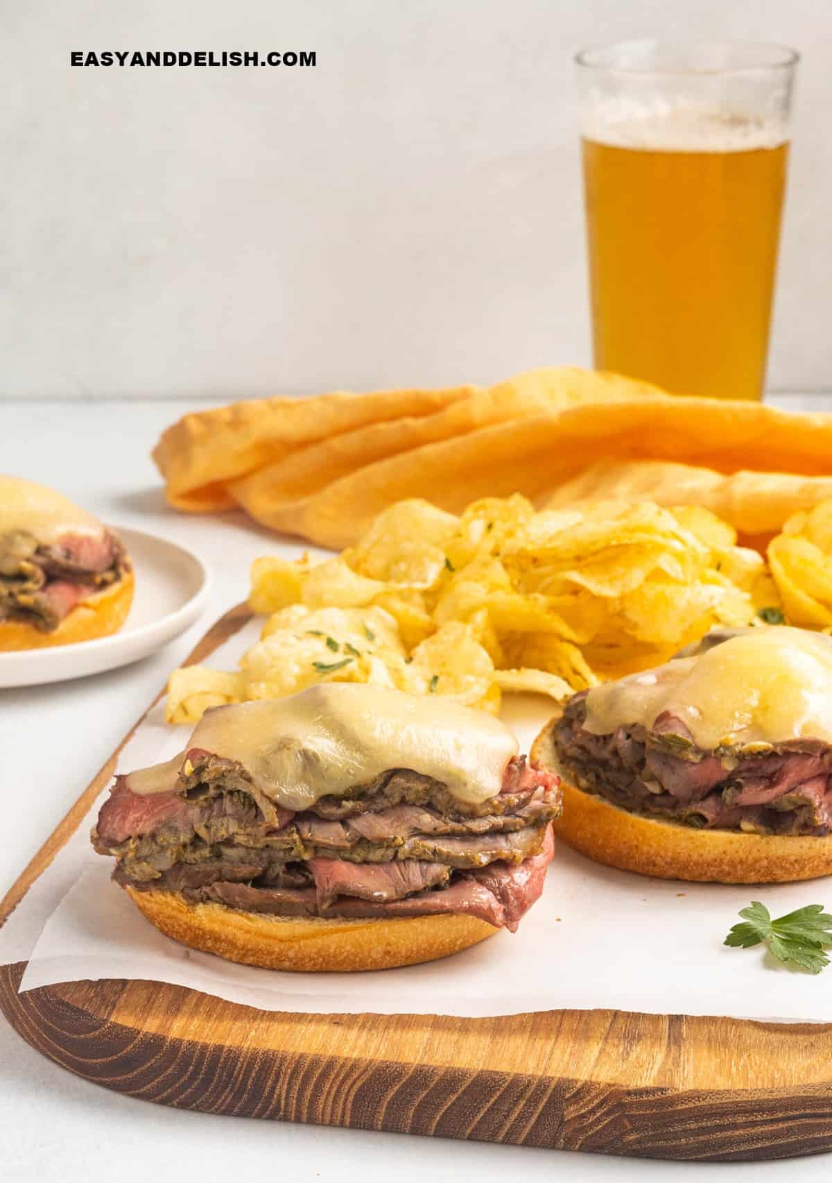 cheese placed on top of the sliced meat stacked on burger buns.