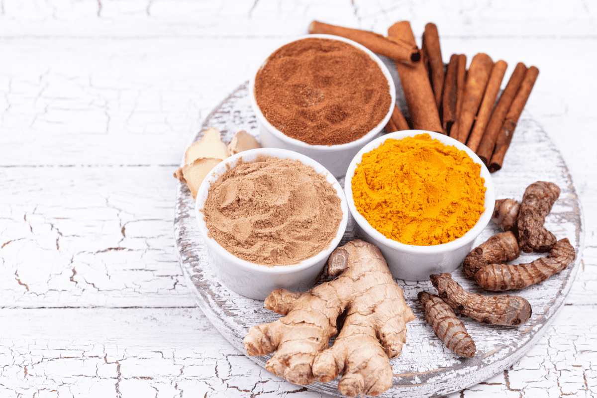 cinnamon, ginger, and turmeric on a table.