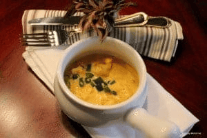 shrimp bobó in a bowl with silverware on the side.