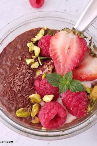 close up image of a jar of chocolate chia pudding garnished with toppings.