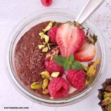 close up image of a jar of chocolate chia pudding garnished with toppings.