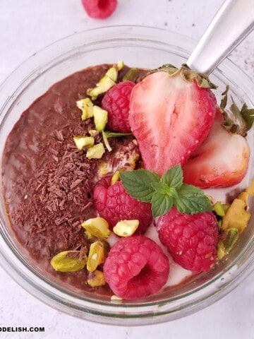 close up image of a jar of chocolate chia pudding garnished with toppings.