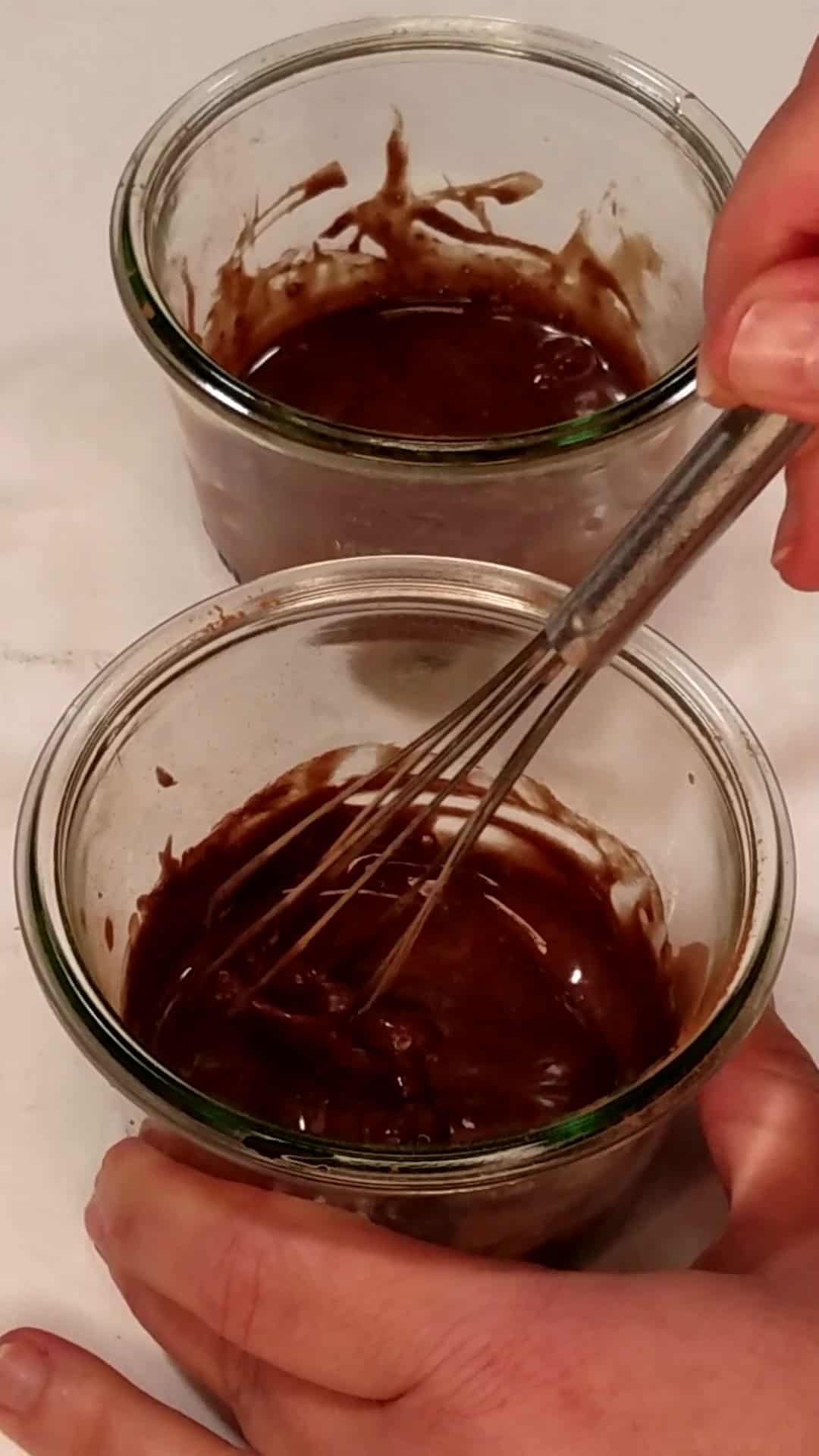 a mixture of cocoa powder, maple syrup, and vanilla mixed in 2 jars.