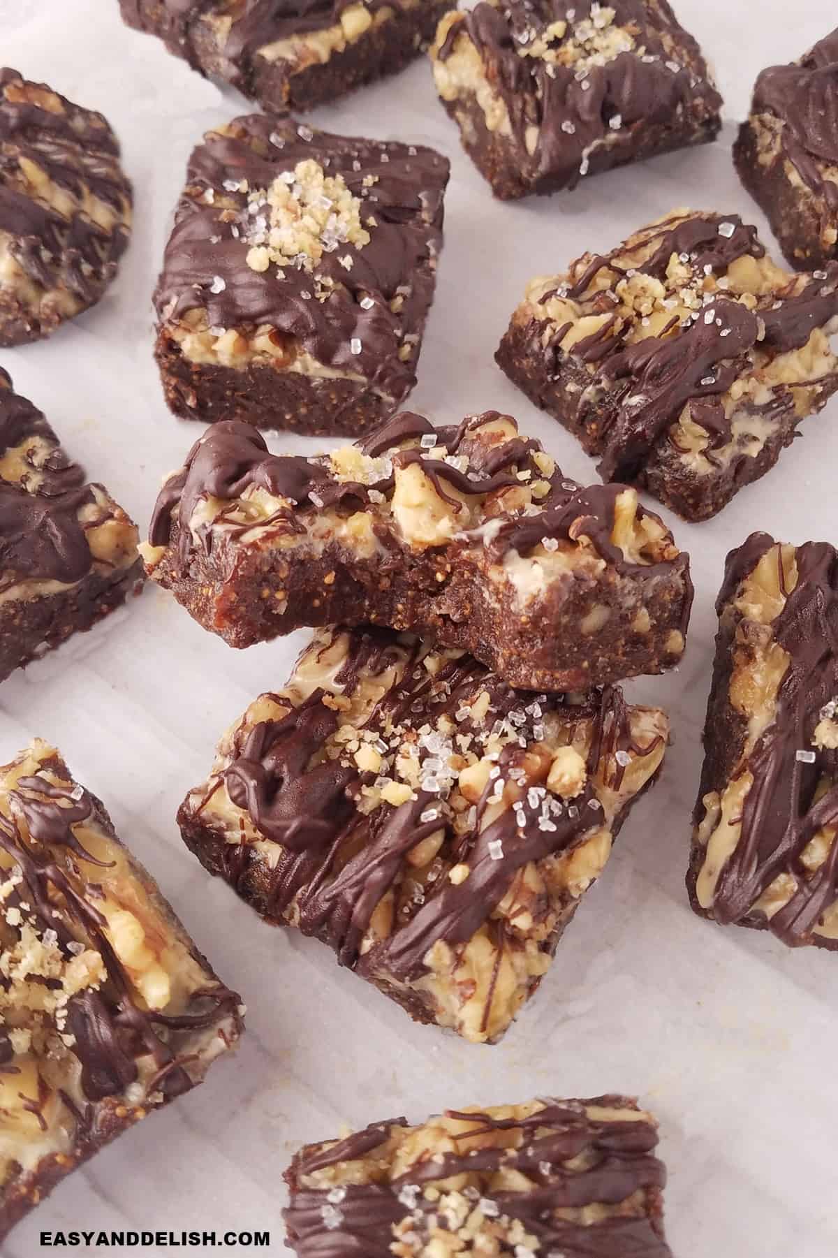 healthy fig bars on parchment paper. Most are whole and one is bitten. 