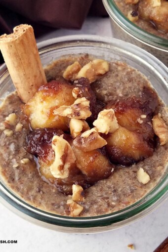 close up of a jar of banana chia pudding topped with caramelized bananas and chopped walnuts.
