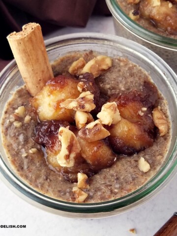 close up of a jar of banana chia pudding topped with caramelized bananas and chopped walnuts.