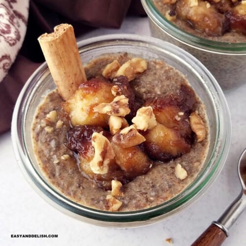 close up of a jar of banana chia pudding topped with caramelized bananas and chopped walnuts.