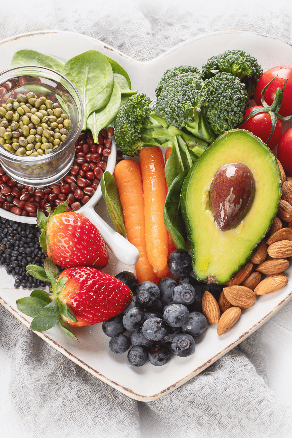 Fruits, veggies, whole grains, and nuts on a heart-shaped platter.