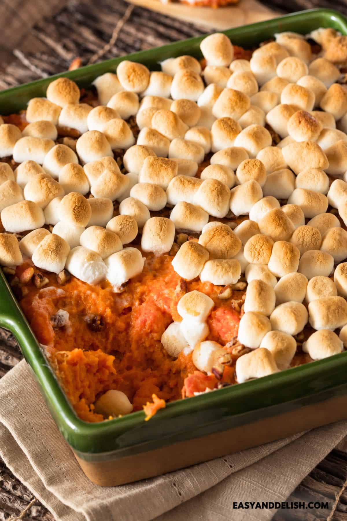 Toasted marshmallows covering a baked sweet potato and pecan filling.