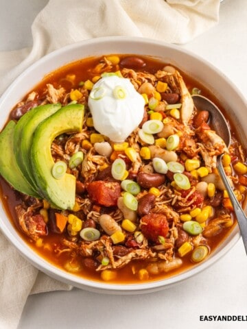 A bowl of healthy turkey chili with toppings.