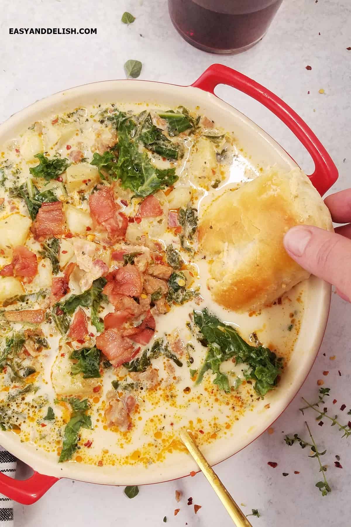 A toast dipped in a bowl of zuppa toscana. 