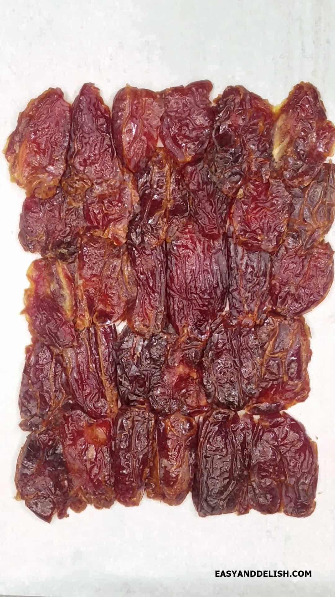 A layer of Medjool dates  on a baking sheet.
