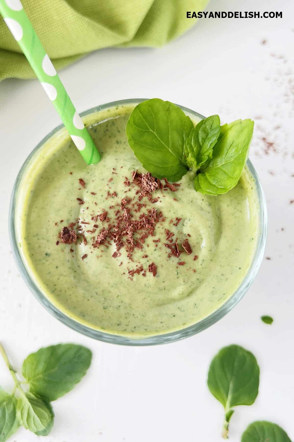 Healthy shamrock protein shake with chocolate shavings and fresh mint leaves. 
