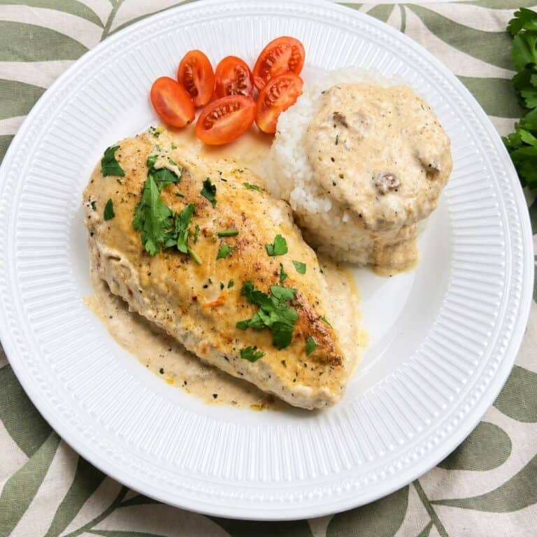Easy creamy chicken dinner served with white rice, cherry tomatoes, and parsley.
